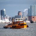 202202_02_ZZ6_9573-orange-tugboat-on-harbor-water-with-city-background-by-E-Girardet.jpg