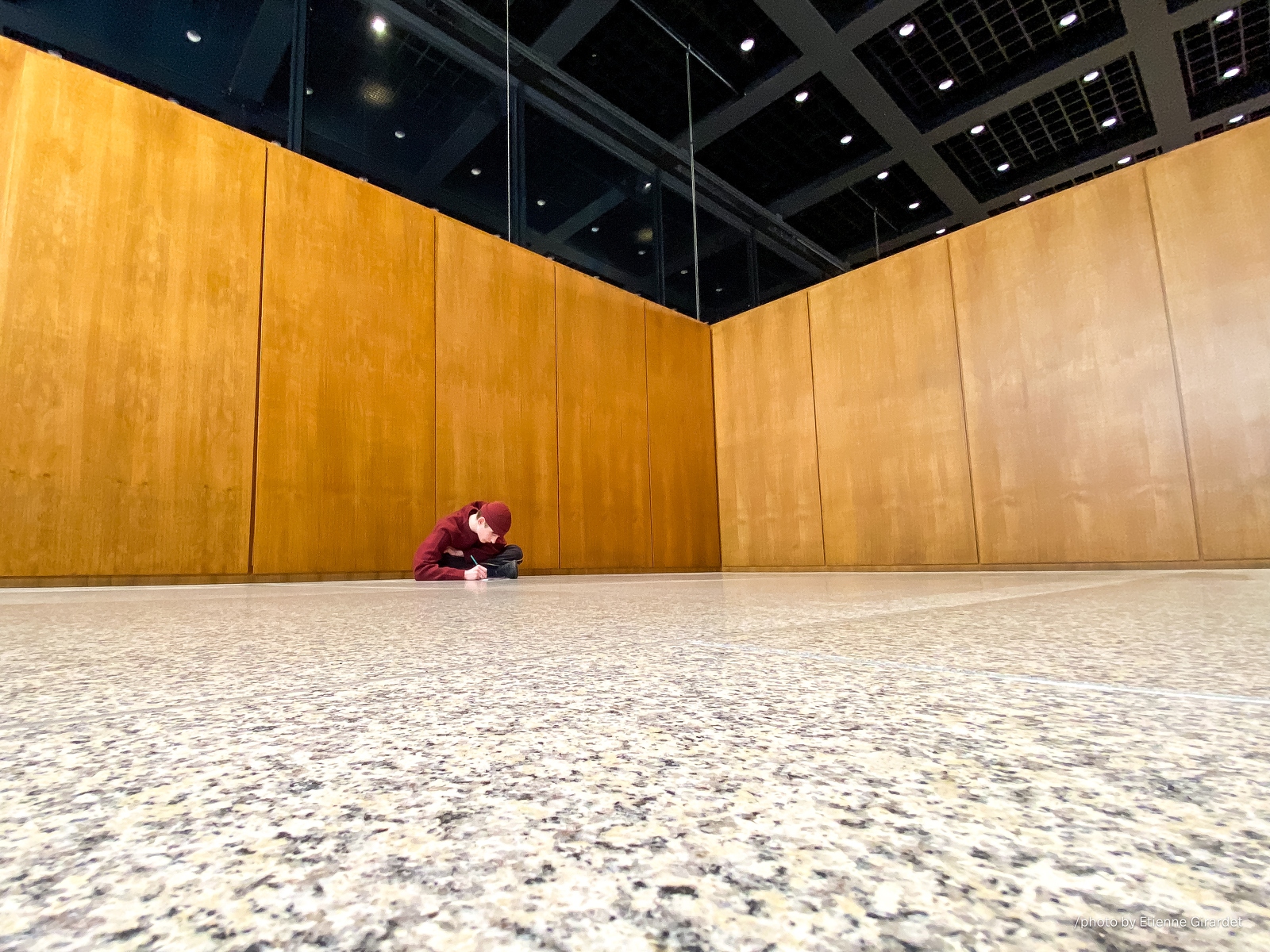 202212_25_IMG_4633-person-sits-writing-on-floor-in-hall-by-E-Girardet.jpg