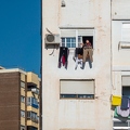 202302_01_RXX02517-woman-drying-clothes-on-balcony-apartment-building-by-E-Girardet.jpg