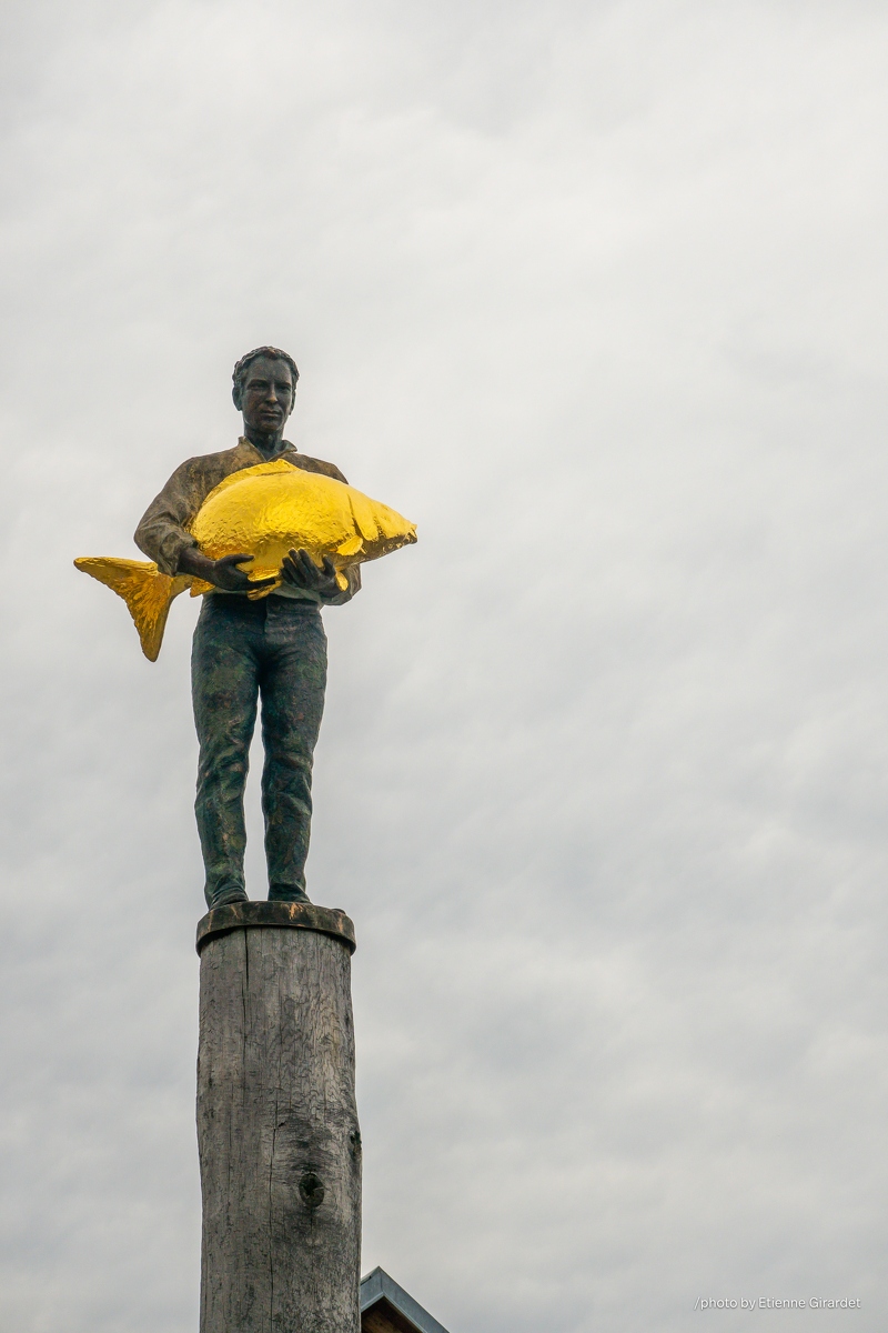 202304_15_RXX03024-man-holds-golden-fish-on-wooden-post-by-E-Girardet.jpg
