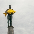 202304_15_RXX03024-man-holds-golden-fish-on-wooden-post-by-E-Girardet.jpg